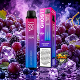 A vape pen and its retail box for the Vapea Day Ghost Pro 3500, shown in front of a dramatic background of purple grapes, ice cubes, and vapor. The packaging is bright pink and purple with 'GHOST' and 'JUICY GRAPESESS' printed on it, and a 'DRAGON' logo is visible in the lower right corner.